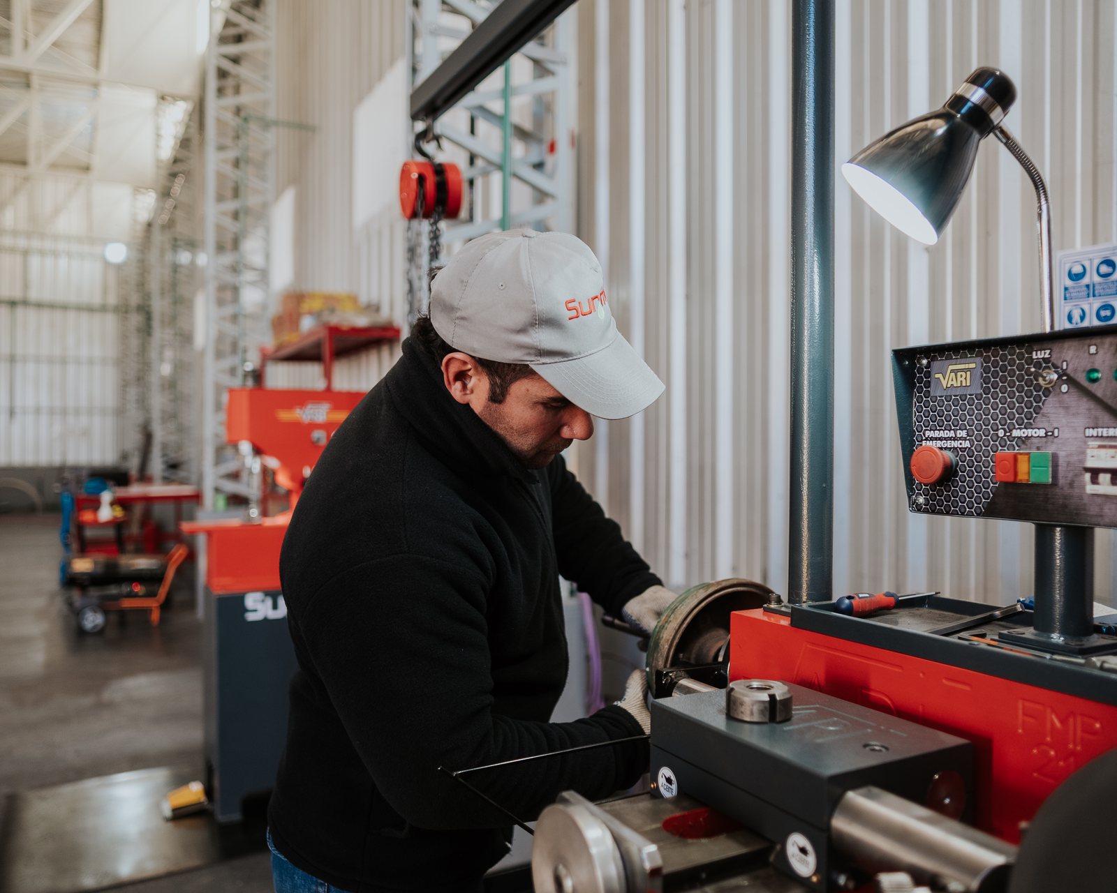 Operario de Surmat con gorra de la empresa trabajando en una máquina rectificadora en el Taller 25 de Albardón